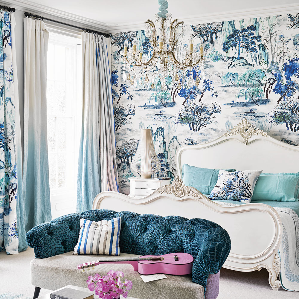 master bedroom with floral wallpaper and sofa with cushion and guitar