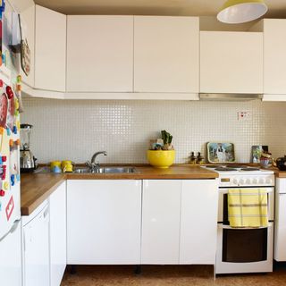 kitchen room with wooden worktop and white wall tiles