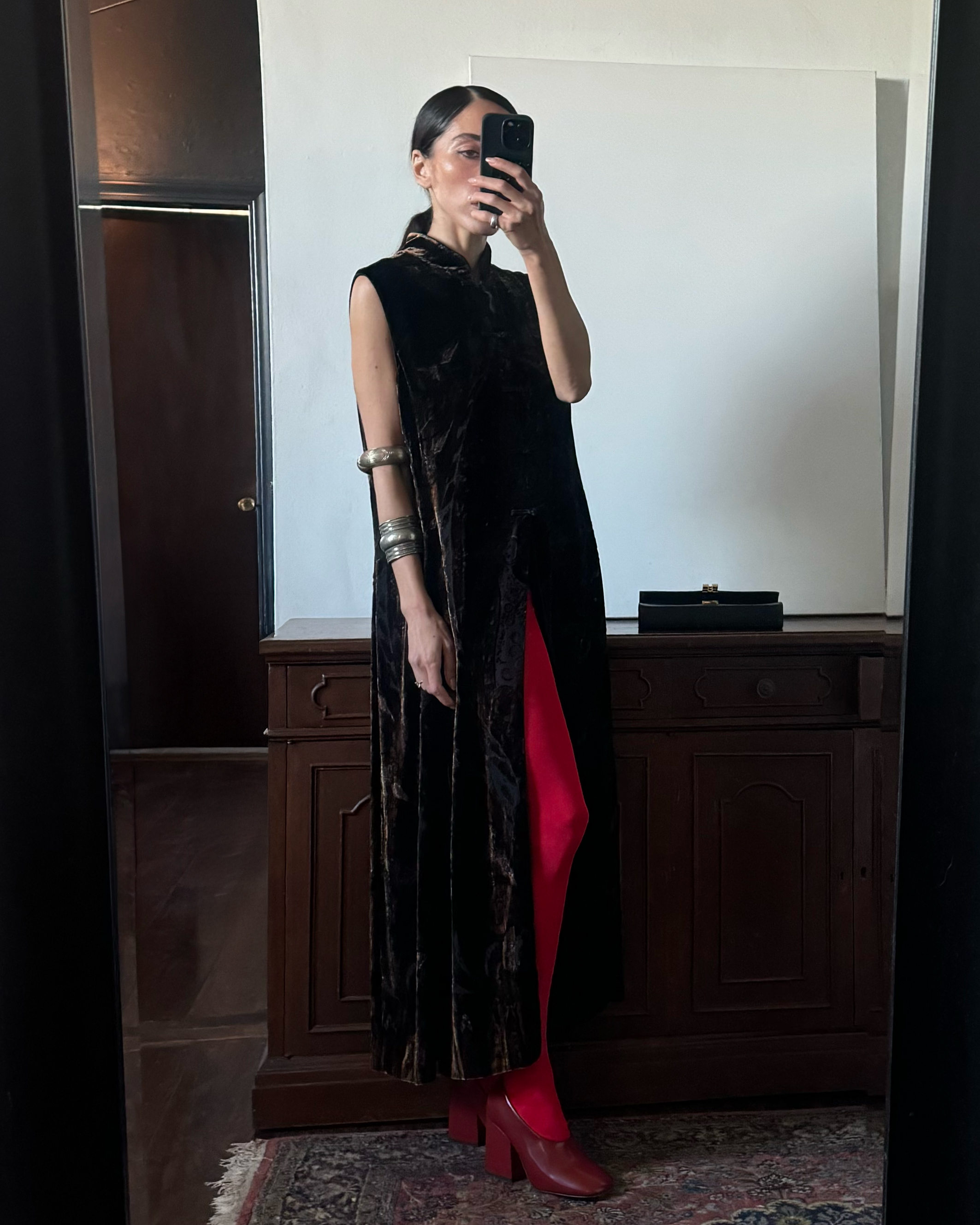 Alexis Badiyi wearing a long opera coat with red tights