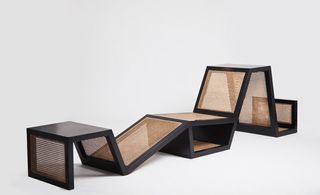 View of 'Living Space III' by Karen Chekerdjian - a multi-use black and rattan piece of furniture