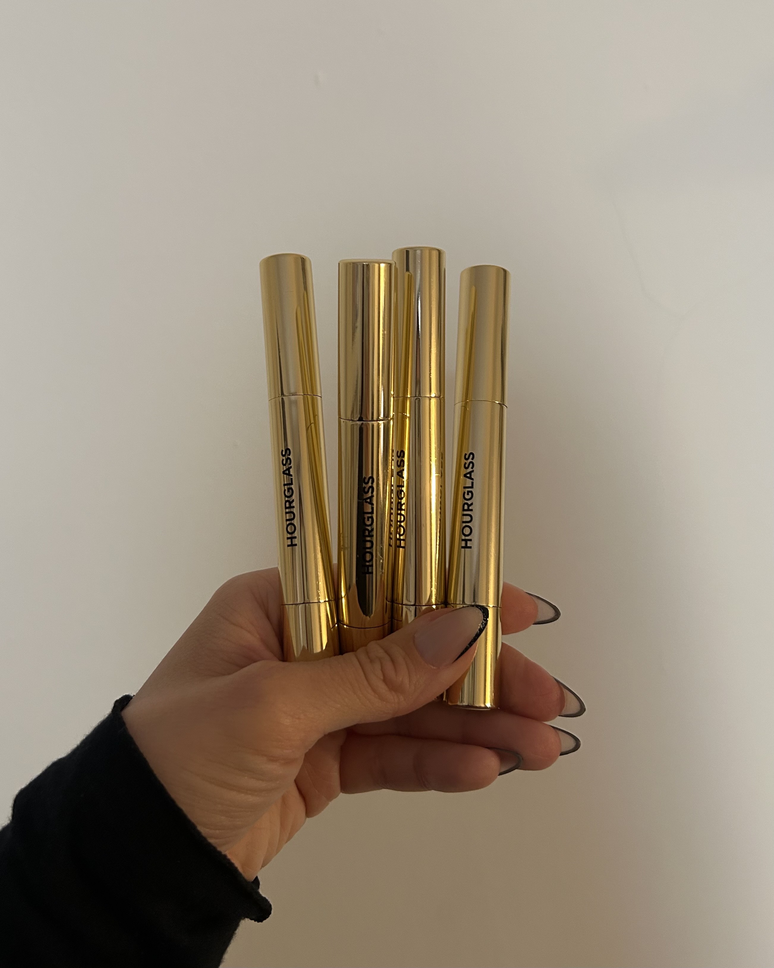 Alyssa Brascia holding several Hourglass Phantom Volumizing Lip Glossy Balms.