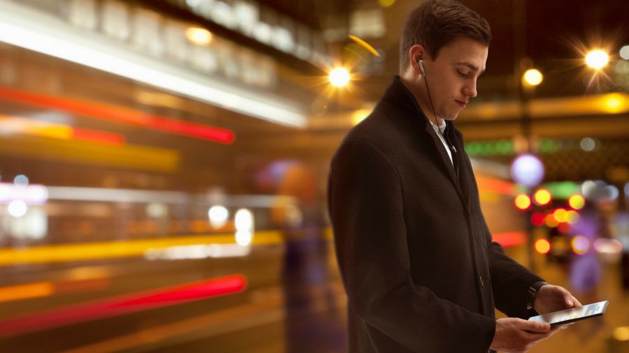 Image of man using mobile phone on a busy city street