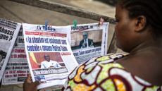 Woman in Benin reads news account of coup attempt