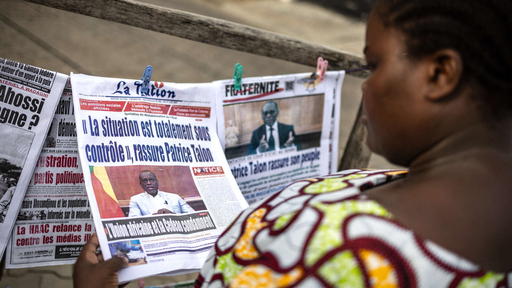 Woman in Benin reads news account of coup attempt