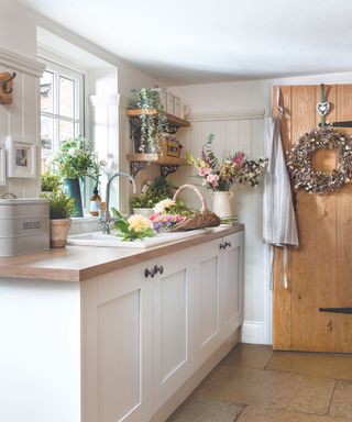 White cabinets, wooden door, stone floor