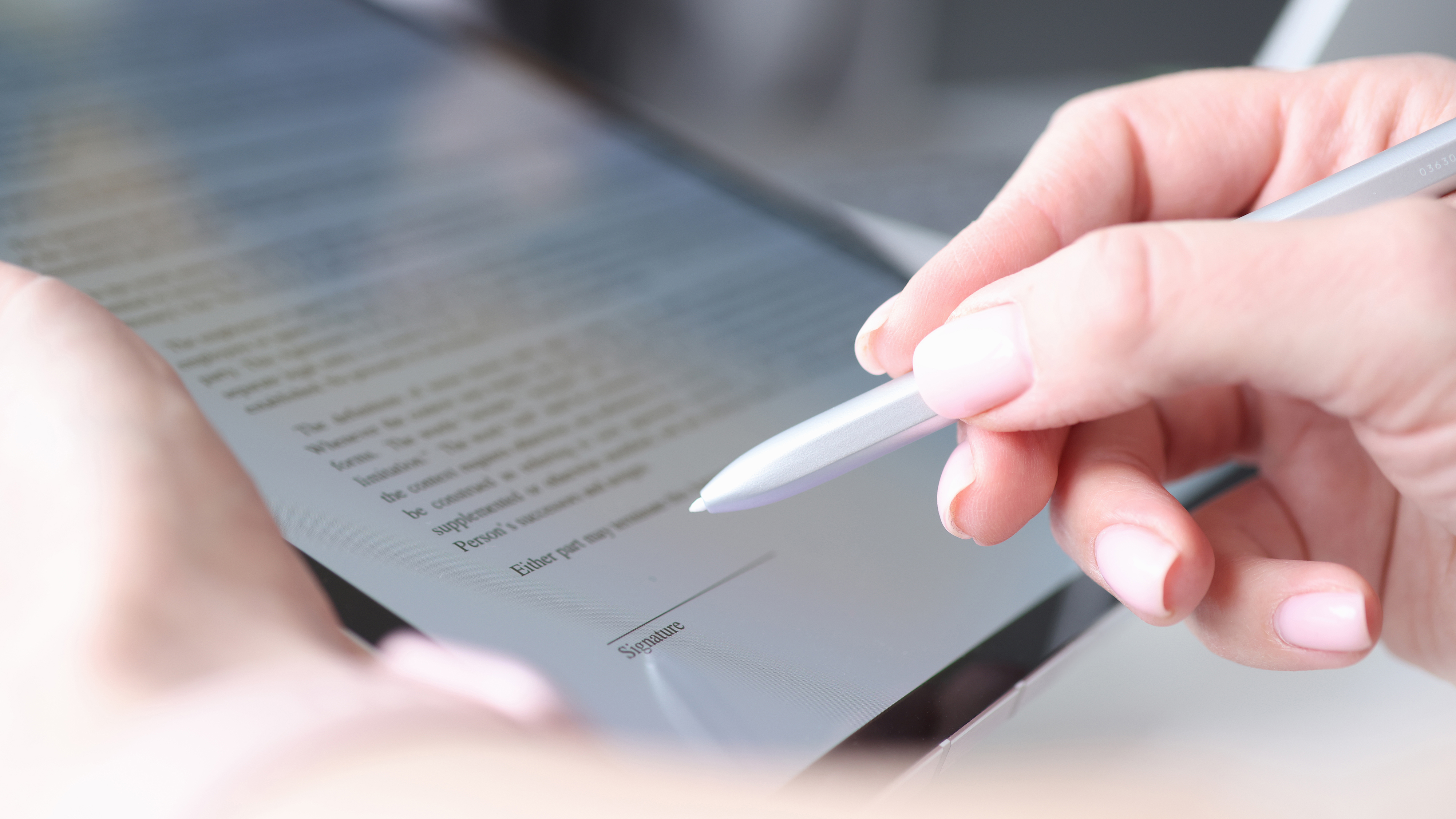 Woman hand holds stylus and puts an electronic signature in contract on tablet, representing an article about how to edit PDFs on iPhone and iPad