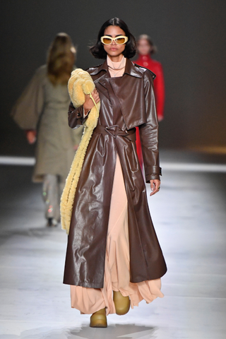 Model wears a brown leather trenchcoat on the runway at Bottega Veneta
