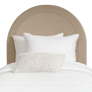 A beige curved headboard with white bedding