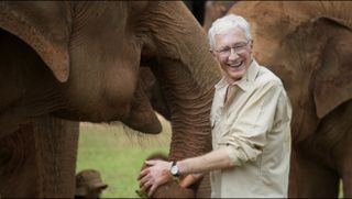 Paul O'Grady's Great Elephant Adventure - Paul O'Grady in a beige shirt standing with an elephant.