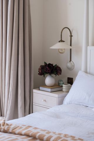 A bedside table lit with wall light