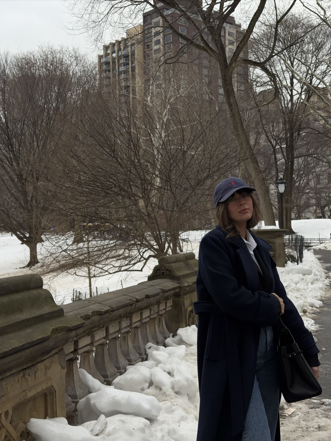 Kathryn Zahorak wearing baseball hat, coat, jeans, boots, black bag in new york city