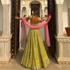 @arentyoueshita wears a pink and lime outfit to an Indian wedding