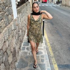 Anna wears a leopard-print dress with black flip-flop kitten heels.