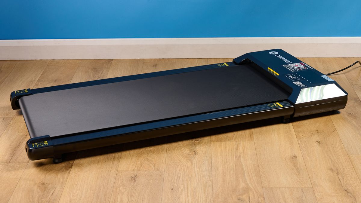 the deerrun q1 mini under desk treadmill walking treadmill in a home office with a blue wall and wooden floor