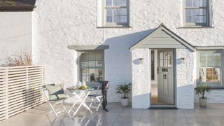 white rendered cottage with small front patio area