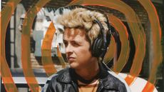 A man with big blonde hair and a leather jacket wearing the Marshall Monitor III ANC headphones with orange circles radiating from his head.