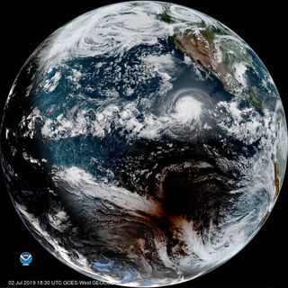 The moon's shadow passes south of Hurricane Barbara during the total solar eclipse of July 2, 2019, in this photo captured by the NOAA/NASA GOES West satellite.