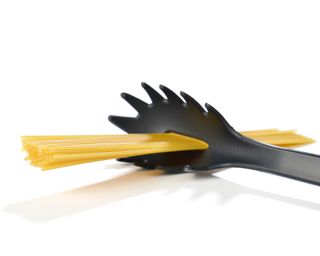 a pasta spoon scoop with spaghetti in the middle hole - GettyImages-1211751510