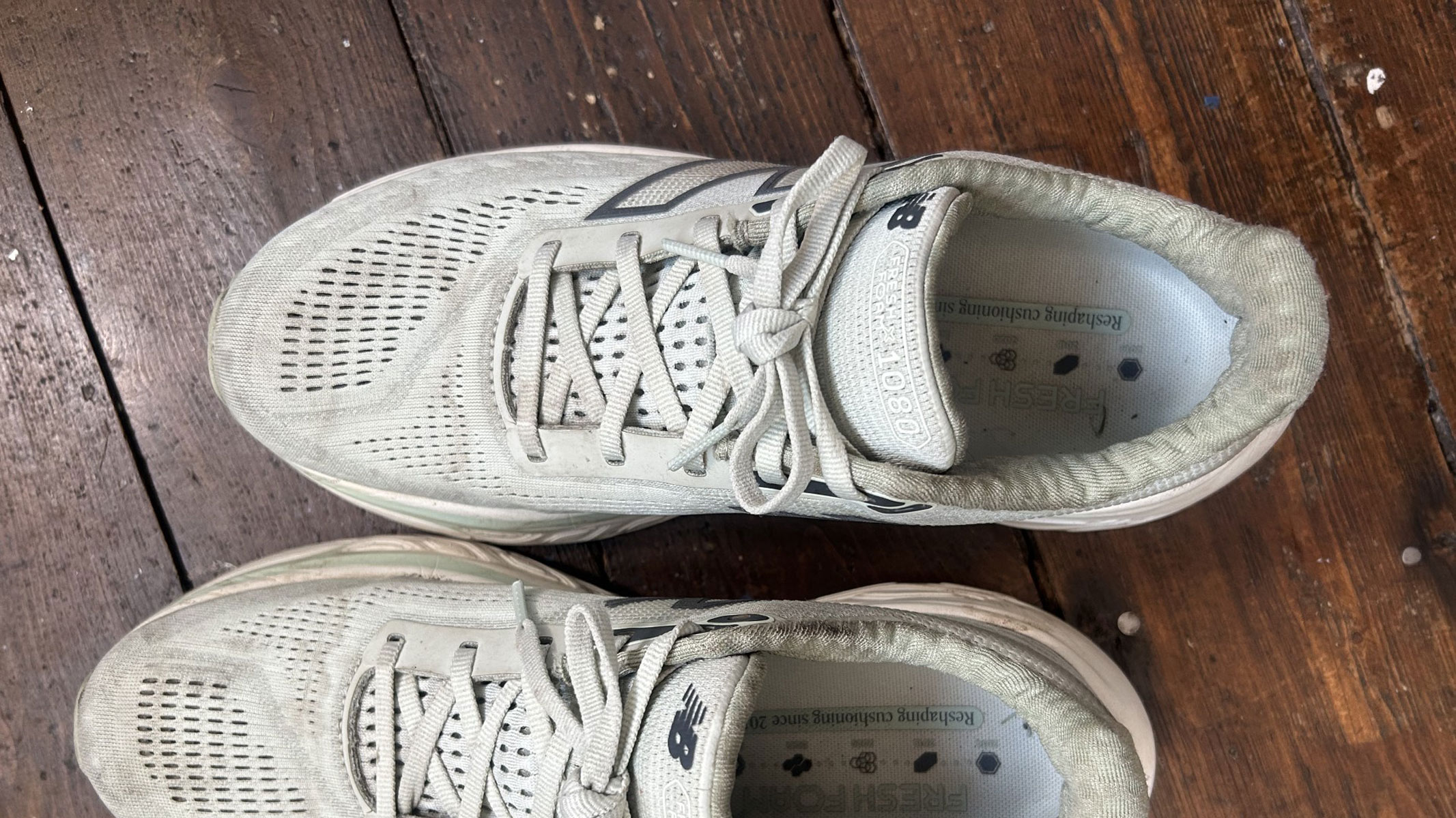 New Balance 1080 v14 running shoes on a wooden floor
