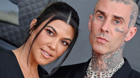 travis barker and kourtney kardashian on a gray background