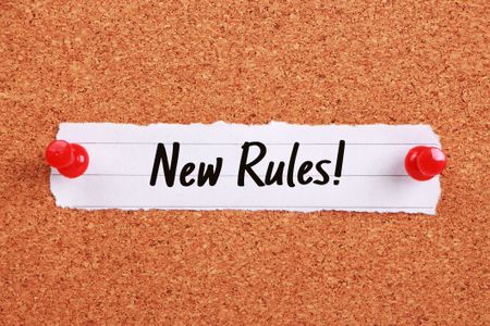 Text says: "New Rules!" and is written on note paper pinned to a corkboard.