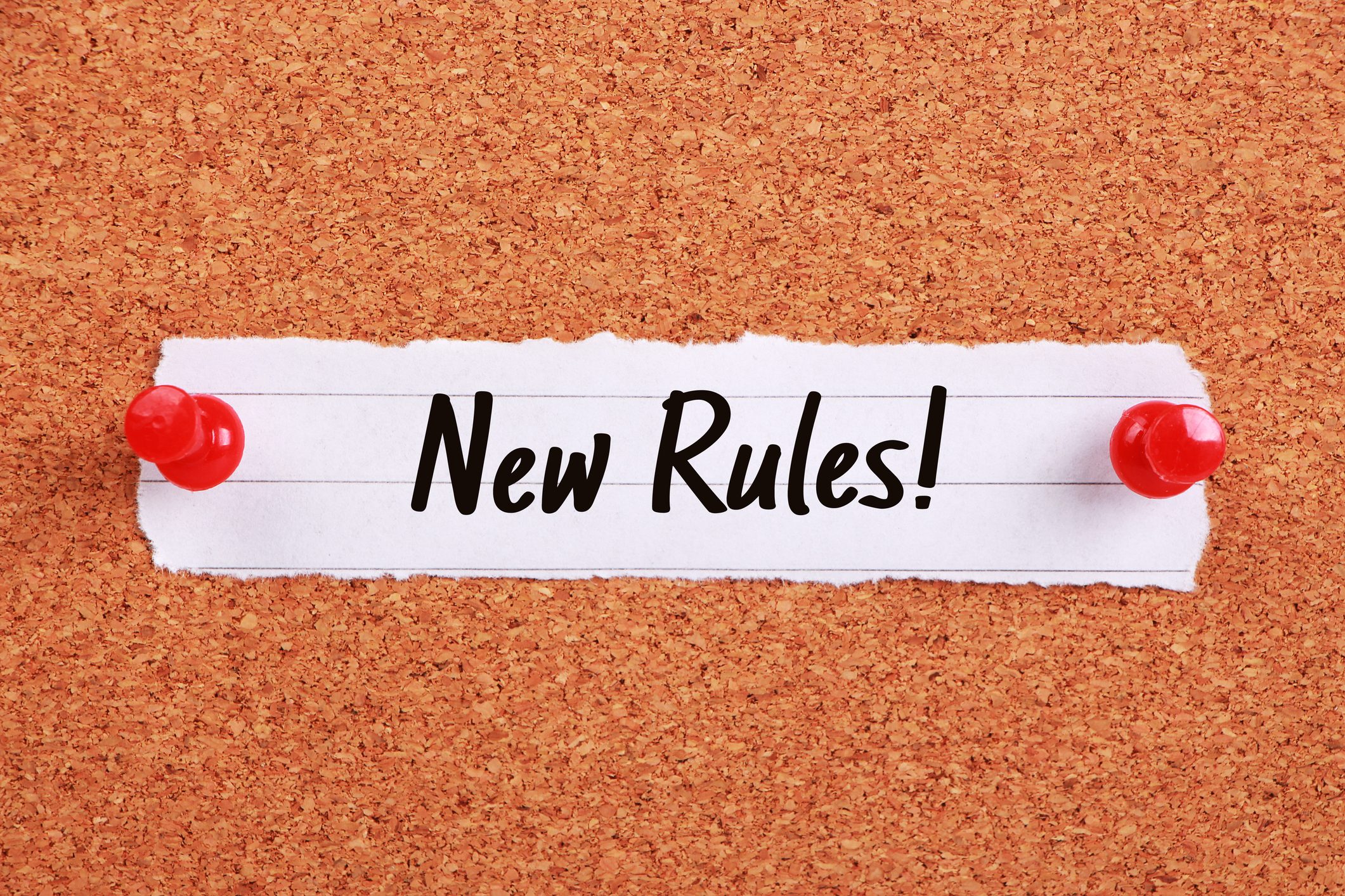 Text says: "New Rules!" and is written on note paper pinned to a corkboard.