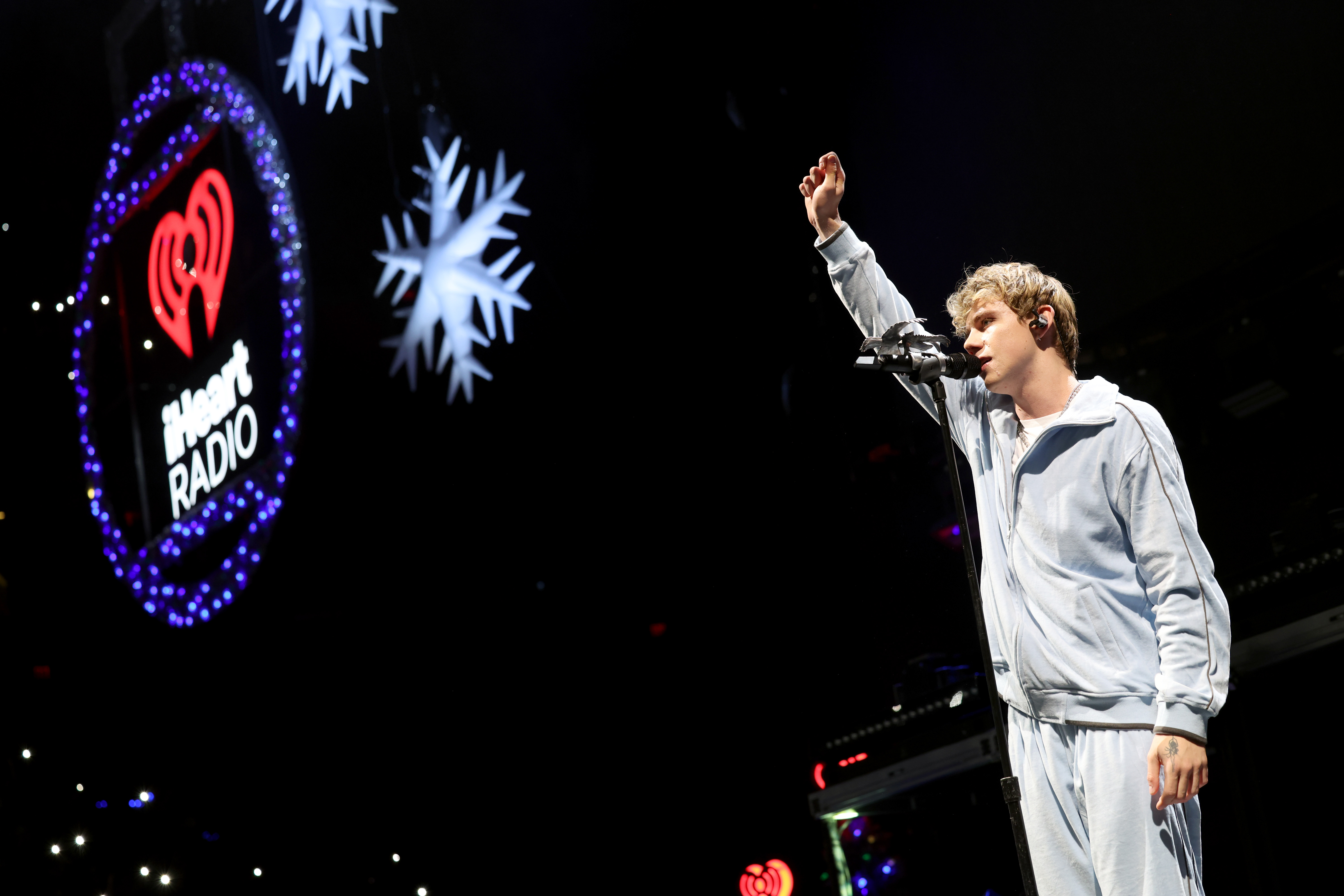 the kid laroi wears a grey sweatsuit while performing at iheart radio jingle ball 2024