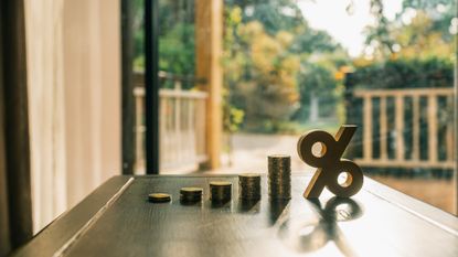 coins and zero percent sign sitting on a table in front of a window
