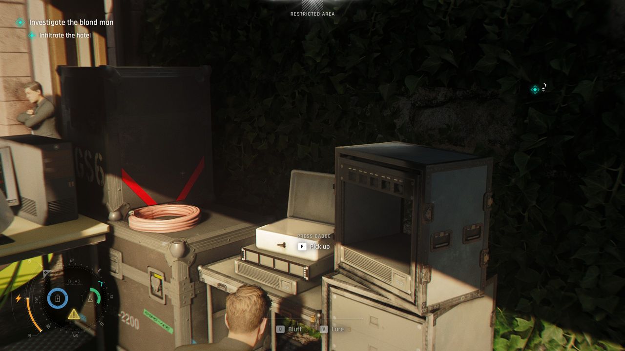 007 First Light - James crouches beside a press badge inside a metal box in a security tent