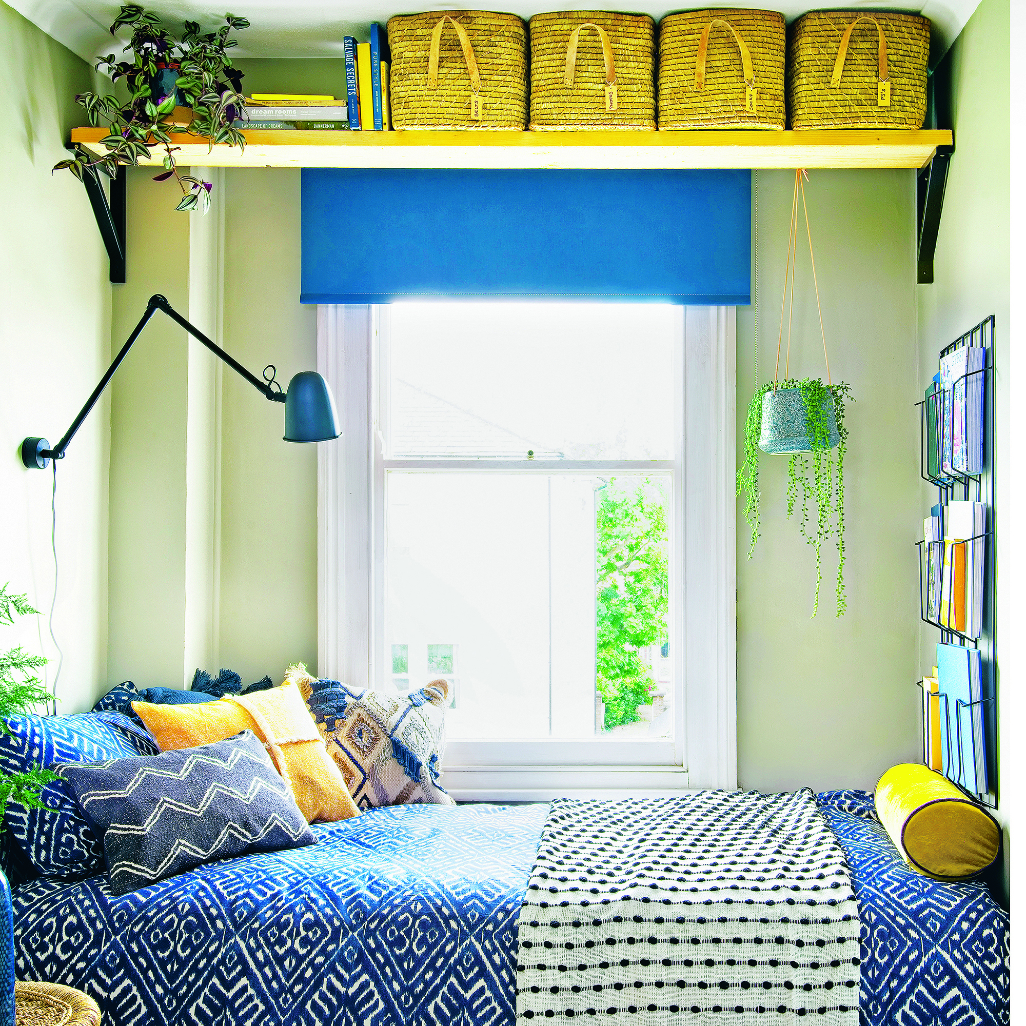 Yellow and blue bedroom with patterned bedding and a window next to the bed.