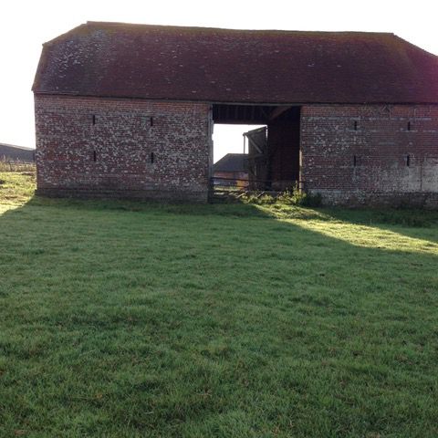 Before: The central barn is now a spacious living area, with floor to ceiling glazing where the barn was originally open for cart access.