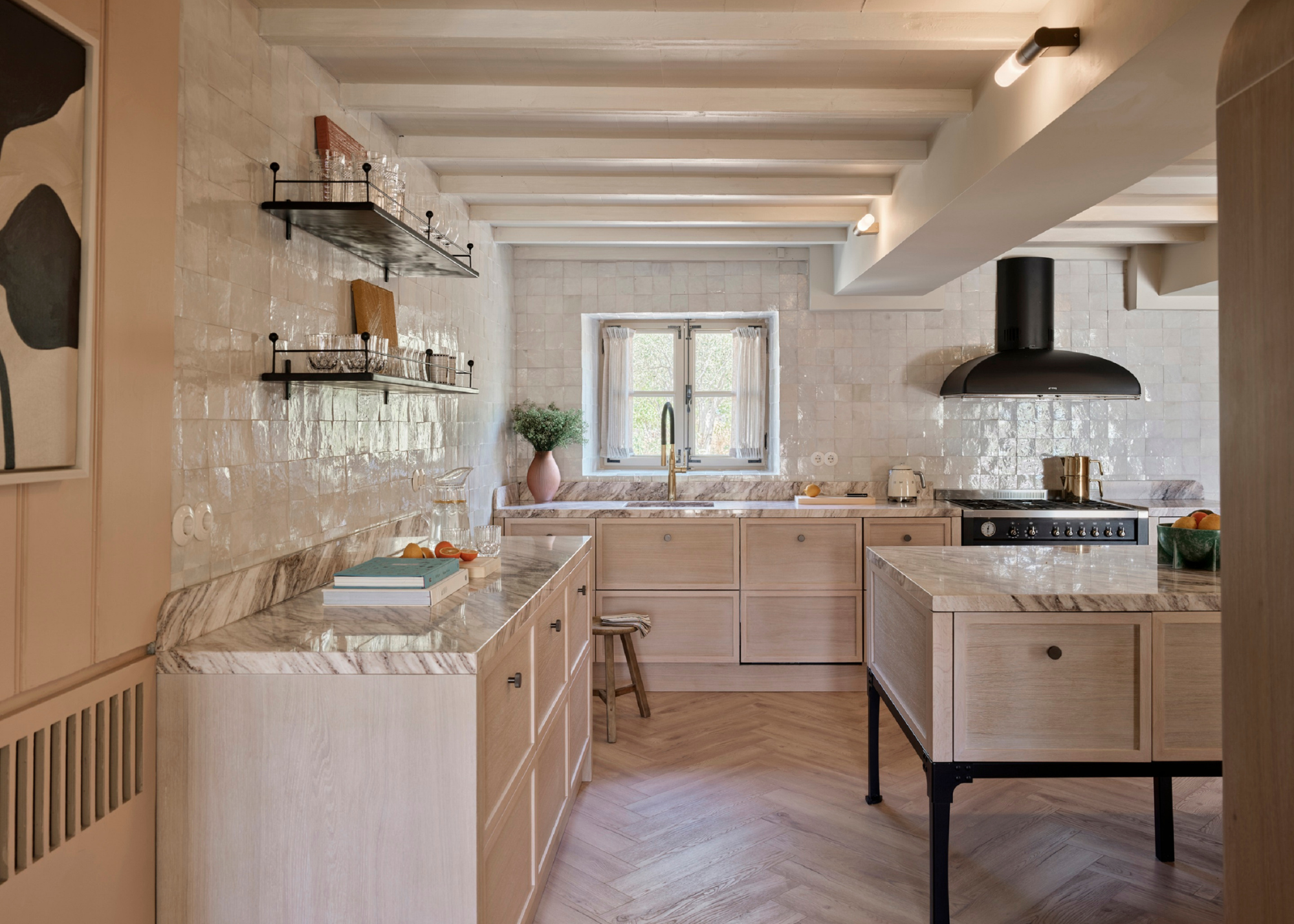 a beautiful, large kitchen with white zellige tile walls, wooden floors and cabinets and marble counters