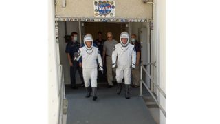 NASA astronauts Bob Behnken and Doug Hurley walk out of NASA's Astronaut Crew Quarters and take a Tesla Model X to Launch Pad 39A during a dry-run test of their SpaceX Crew Dragon Demo-2 flight on May 23, 2020 at the Kennedy Space Center in Florida.