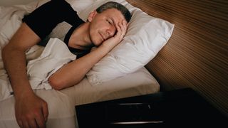 Man lays awake in bed