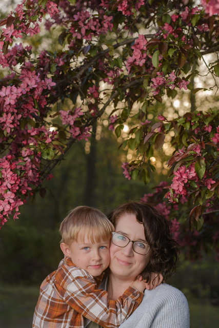 A mom with her child under a blossoming cherry tree