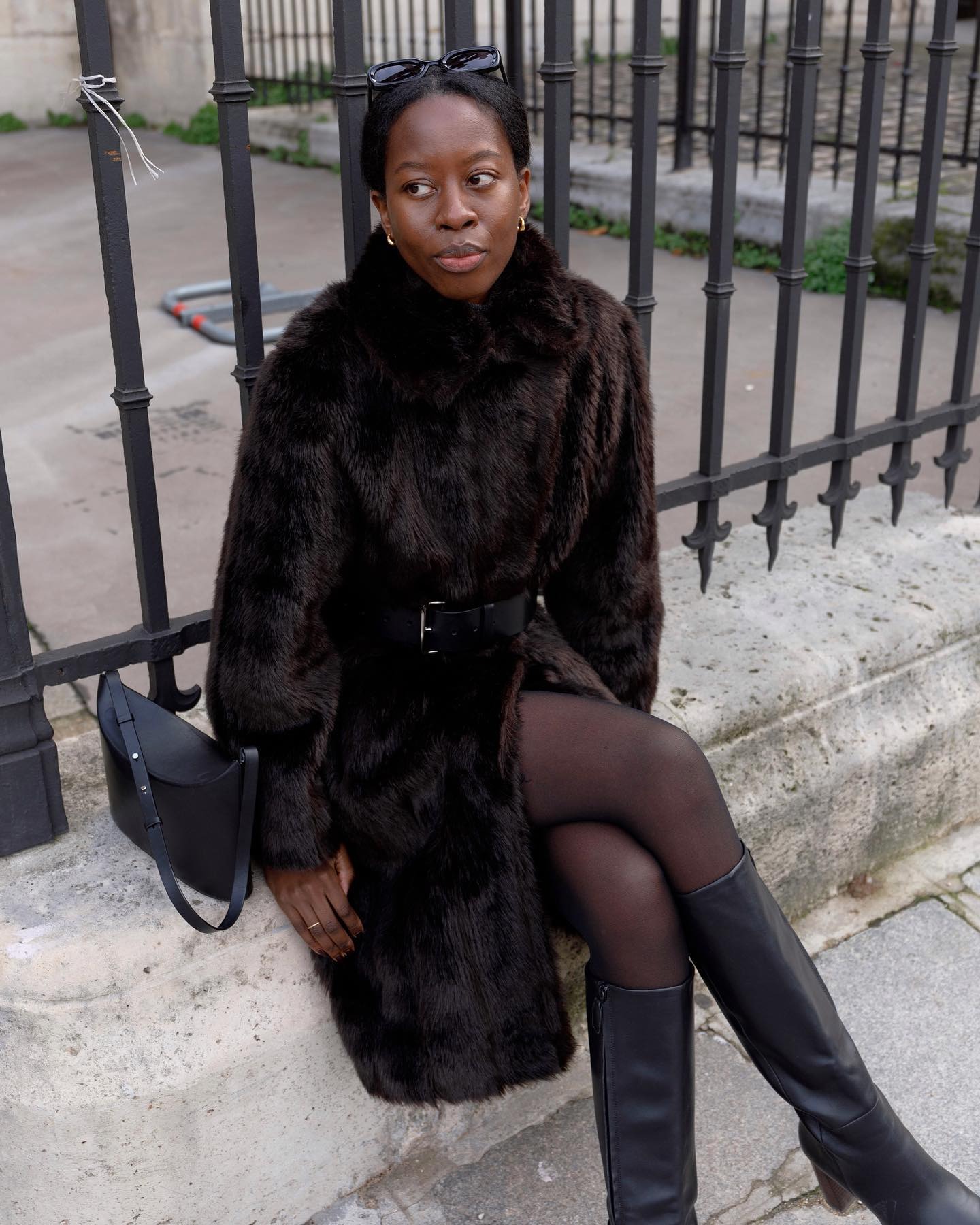 @sylviemus_ wearing a fur coat, belt, and tights.