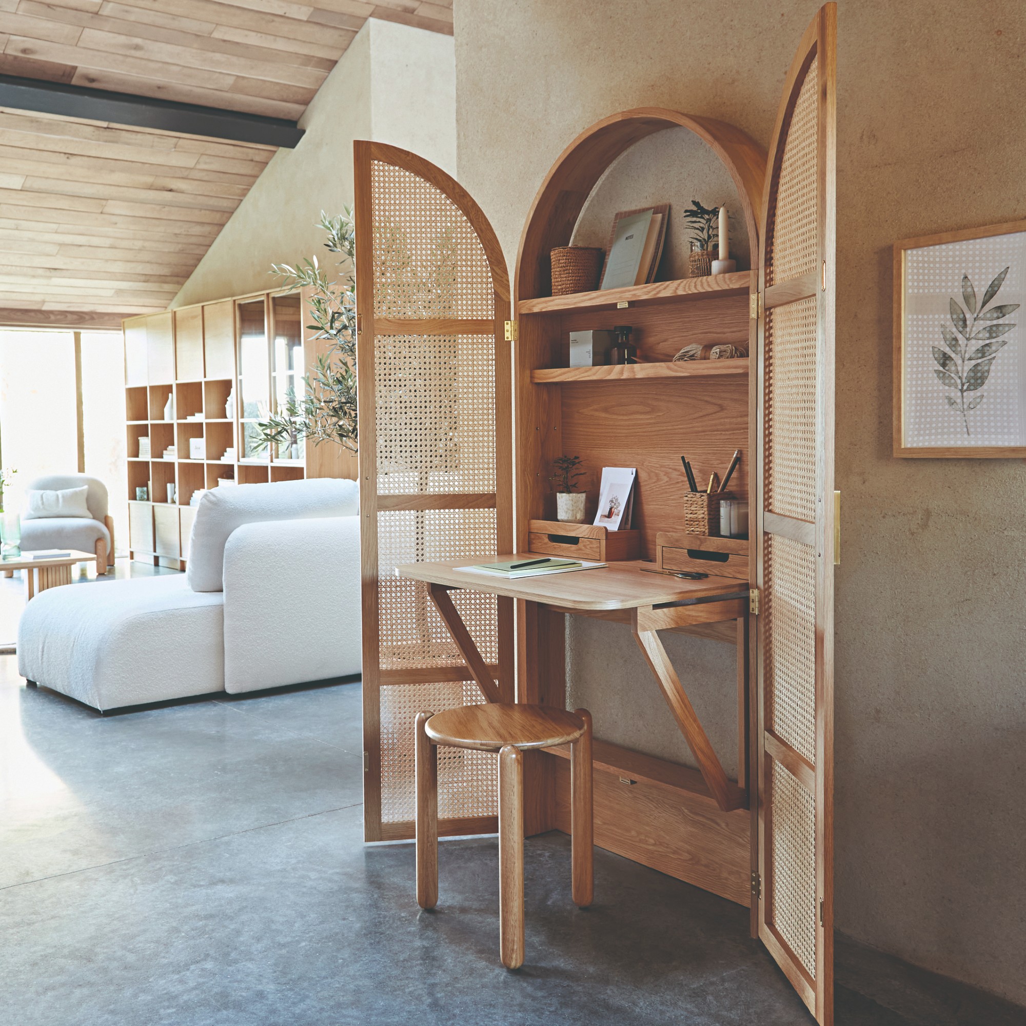 The Matheo hideaway cabinet desk by La Redoute open in a large, open-plan living room