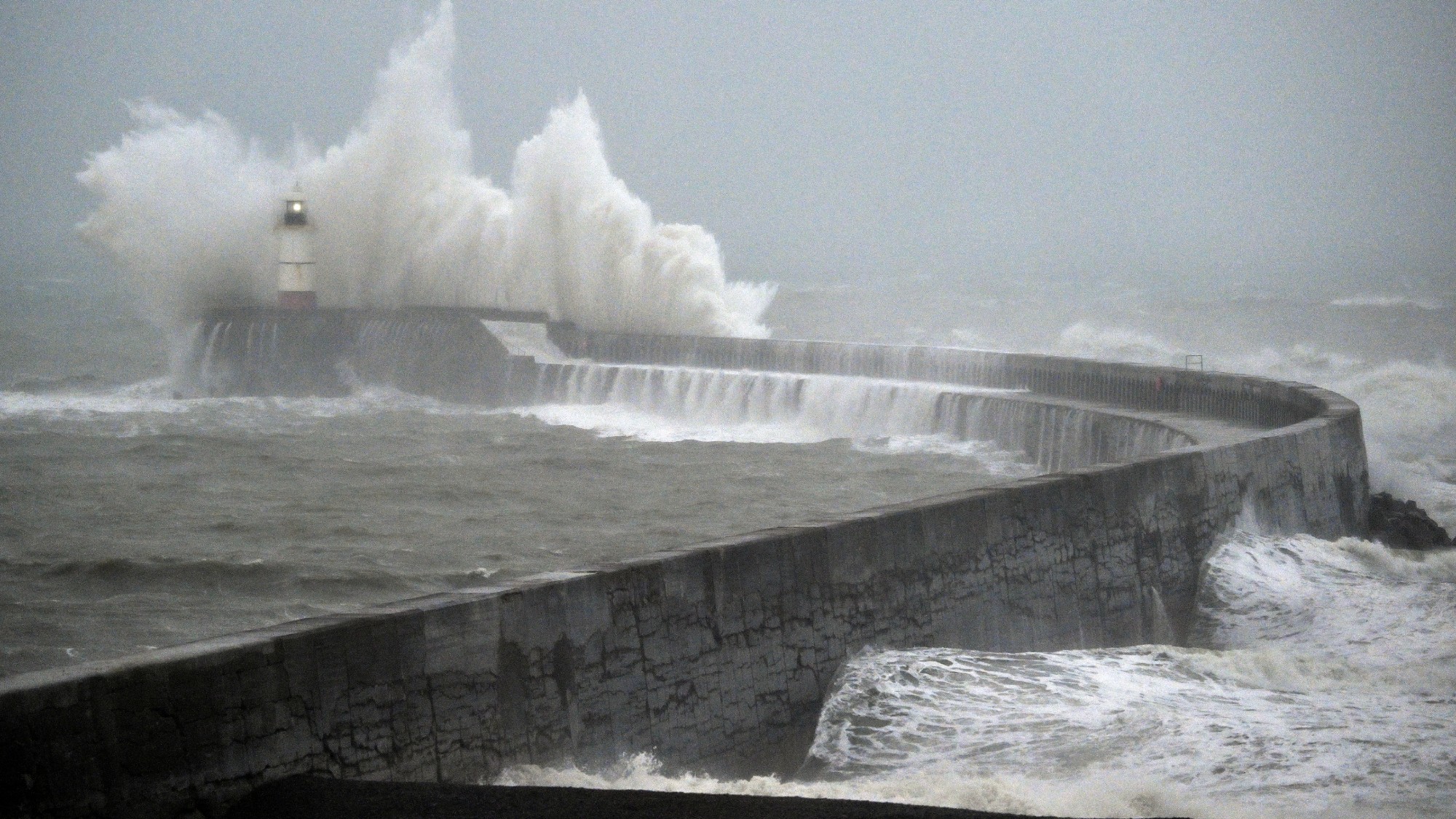Waves crash over Newhaven lighthouse as Storm Austen hits southern England