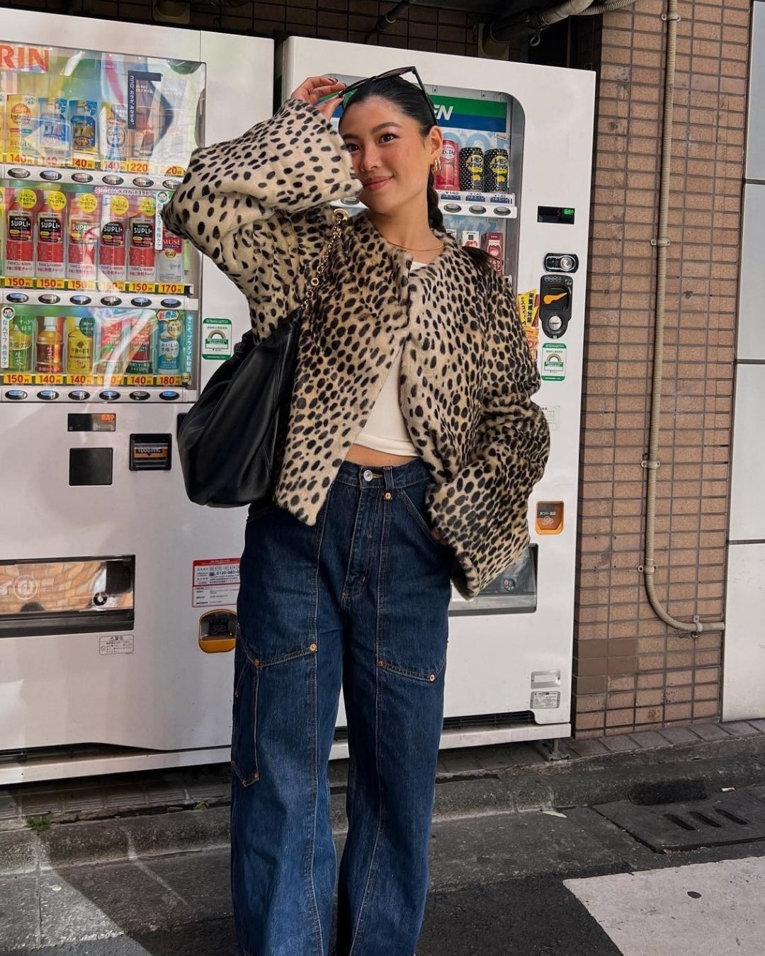 Influencer @michellengatimin wears a leopard print jacket with dark was jeans and a black leather bag.