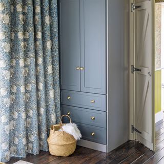 green bedroom with blue wardrobe and blue floral curtains
