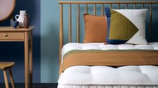 Mattress, wooden bedframe, blue wall, wooden desk
