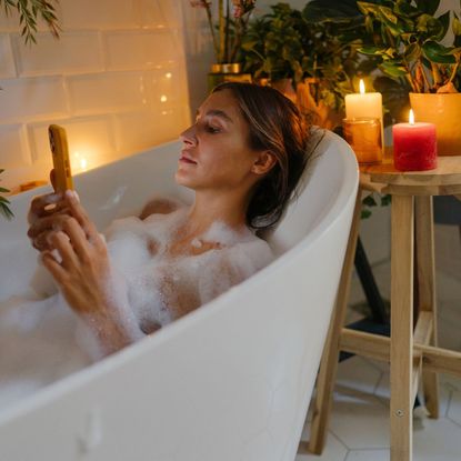 Best self care apps: A woman using one of the best self care apps on her phone