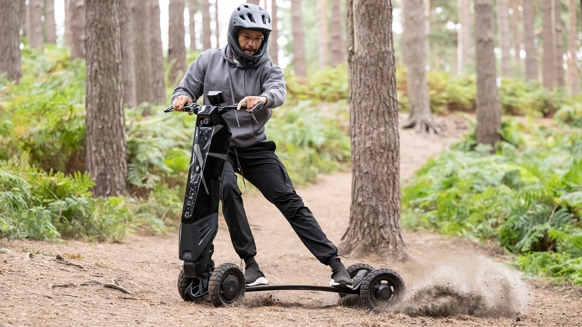 Man riding the D-Fly Dragonfly electric scooter in the woods