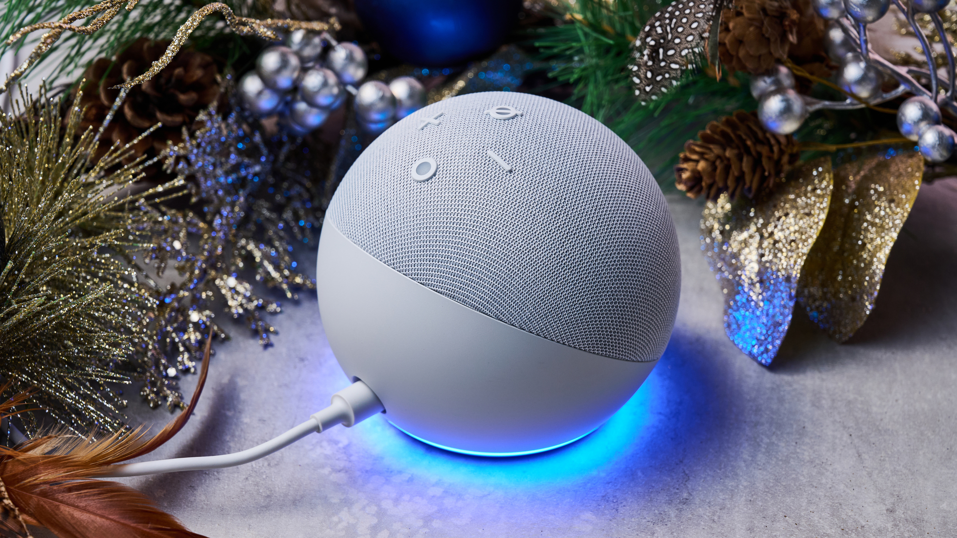 A view of the back of the Amazon Echo Dot, which is surrounded by a festive garland.