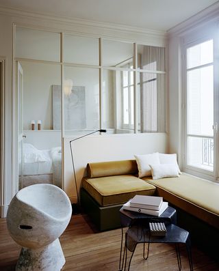 An alcove bedroom that has been partitioned from the living room with a glass wall