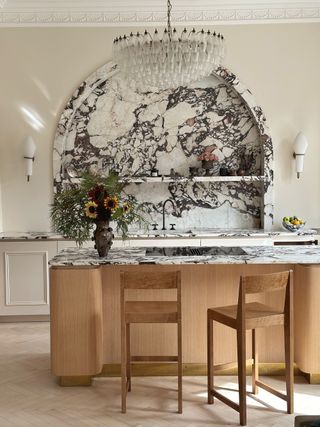 a marble and wood kitchen with a murano glass chandelier