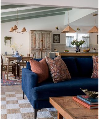 kitchen with living room space with a navy couch and colorful accessories