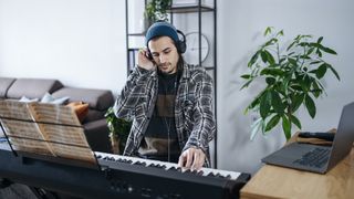 Pianist lifts one earcup of his headphones