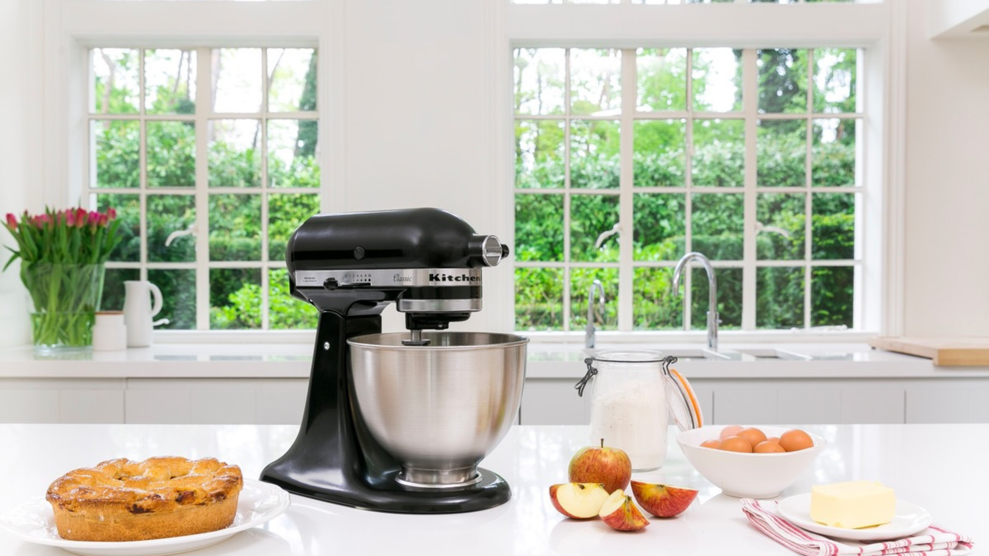 KitchenAid stand mixer in black on a white kitchen island.