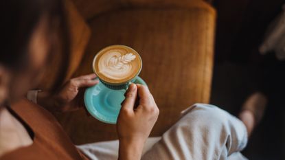 a woman sitting enjoying a cup of coffee